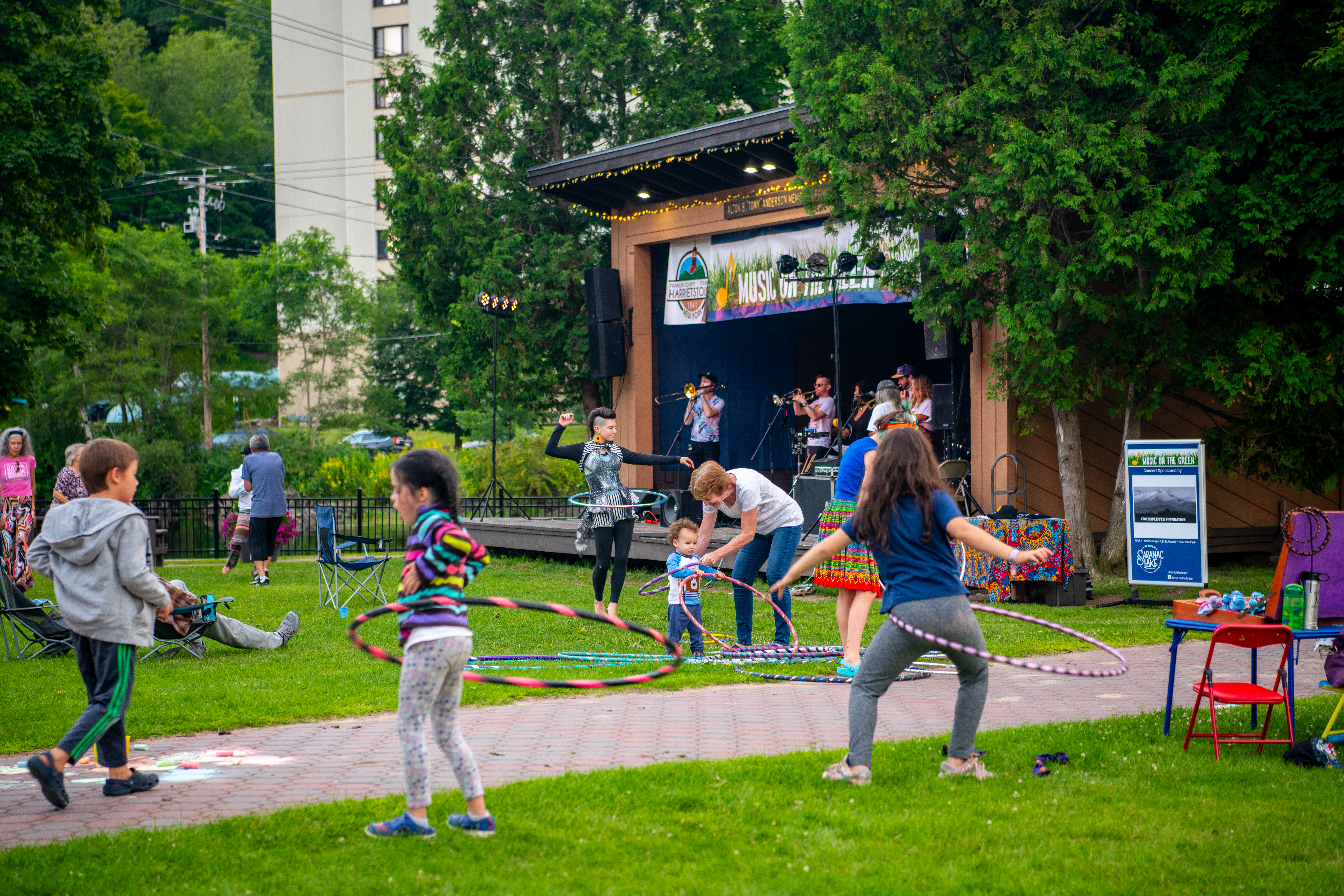 Several kids hula-hoop to live music