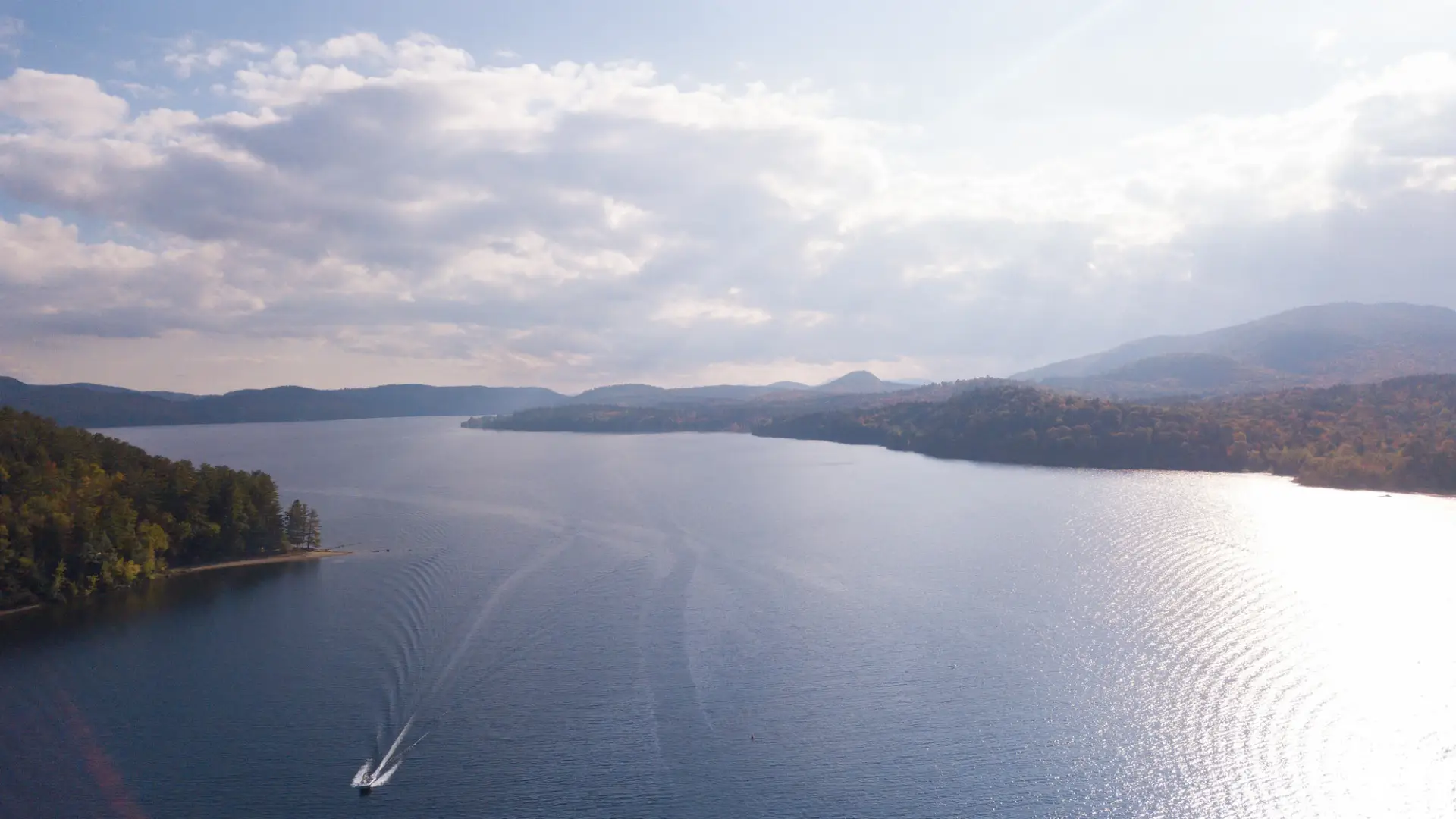 A boat leaves a wake in this aerial view of Schroon Lake