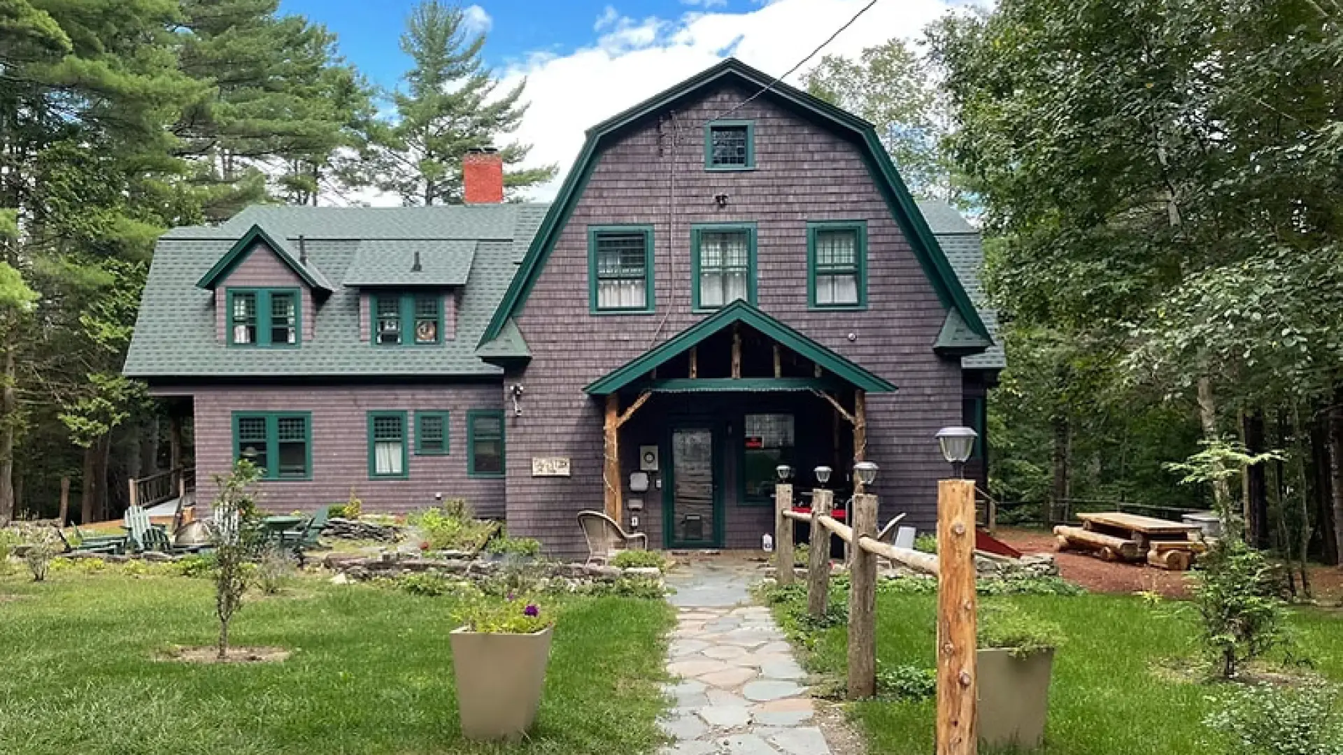 picture of the front of the Tavistock Lodge. Brown Building with Green Roof 