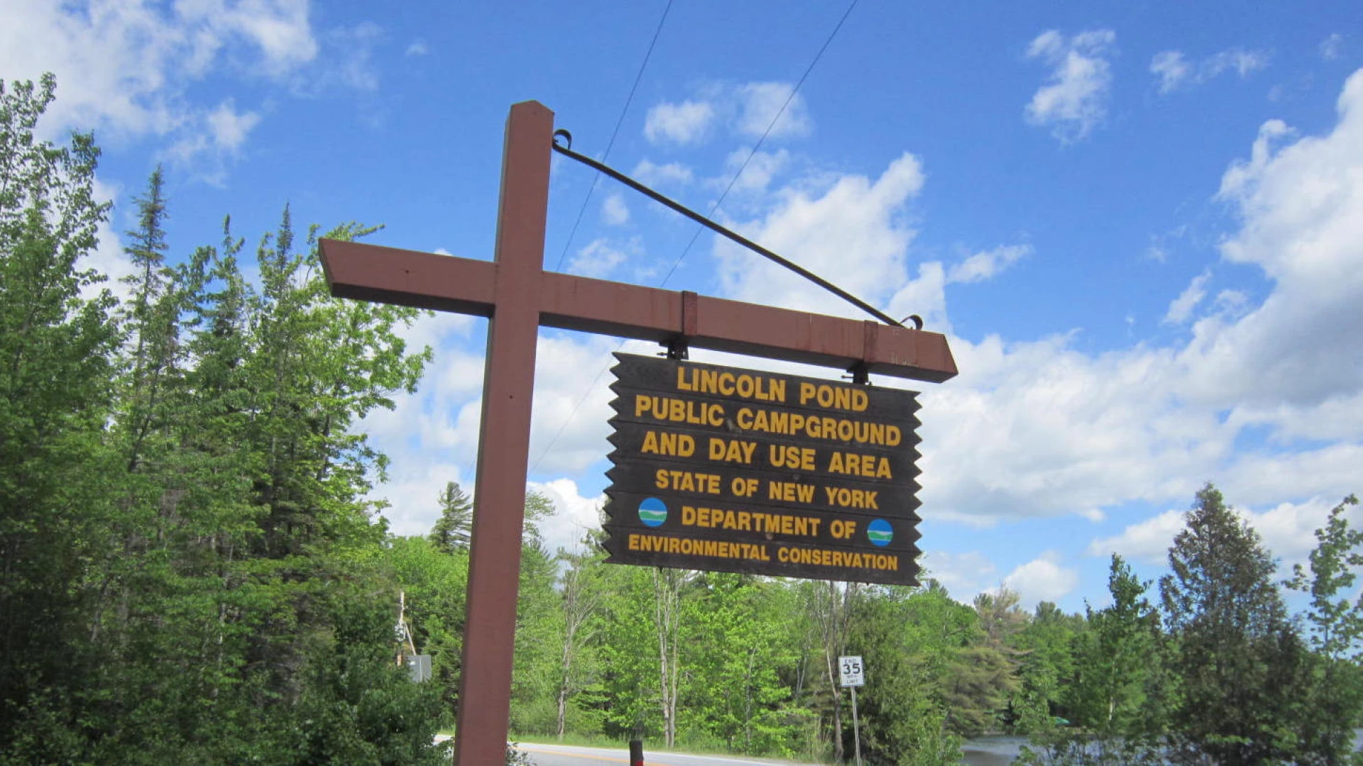 A yellow and brown sign marking a campground entrance.