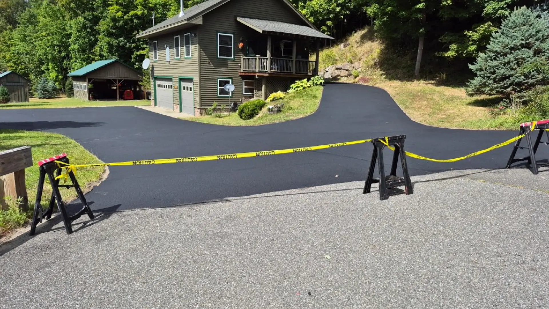 freshly sealed driveway with caution tape