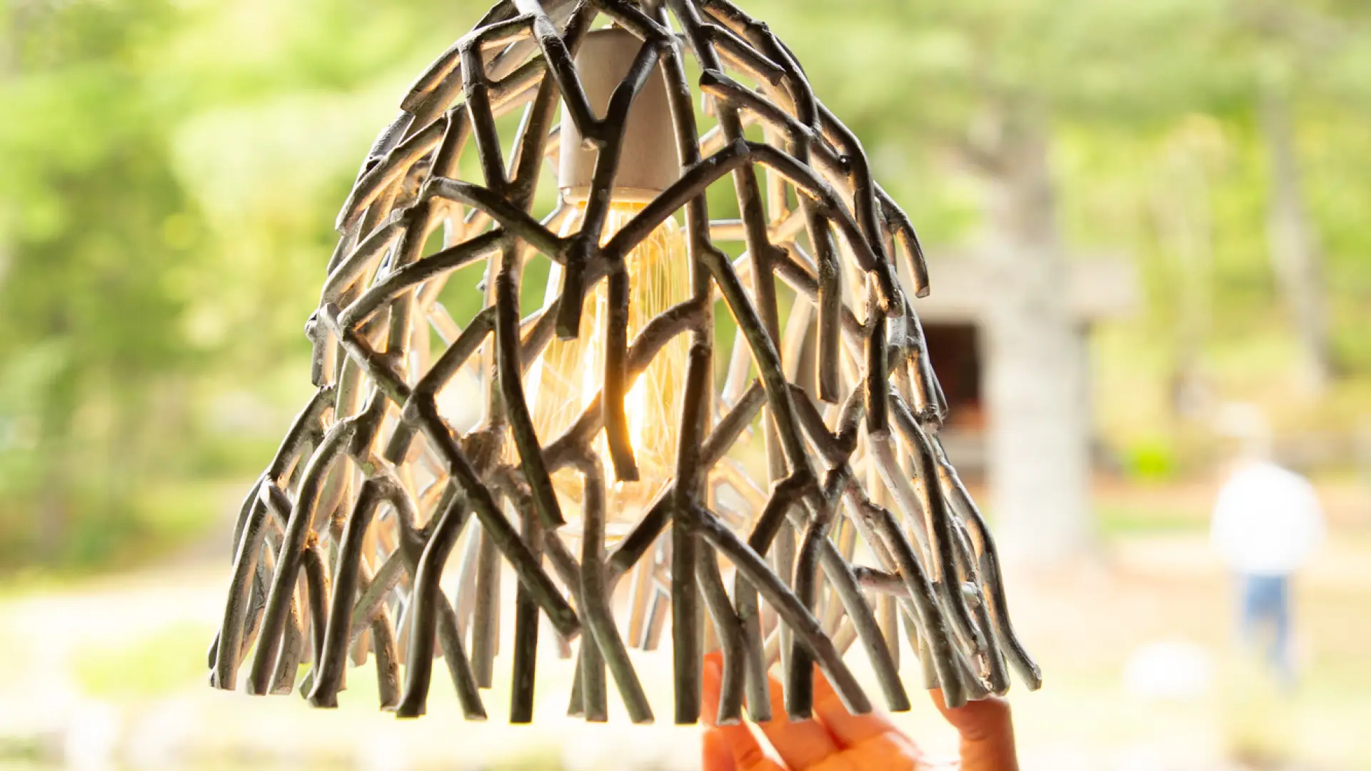 a hanging lamp that is made out of metal but in the design of twigs surrounding the light