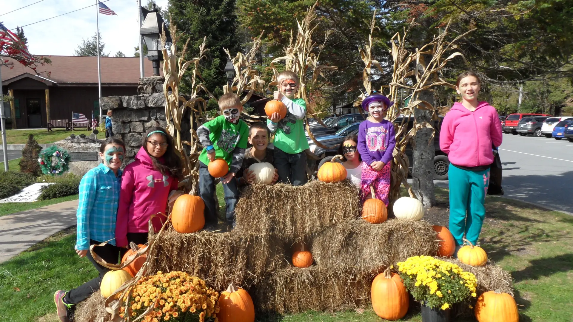Kids sitting around hay bales in autumn