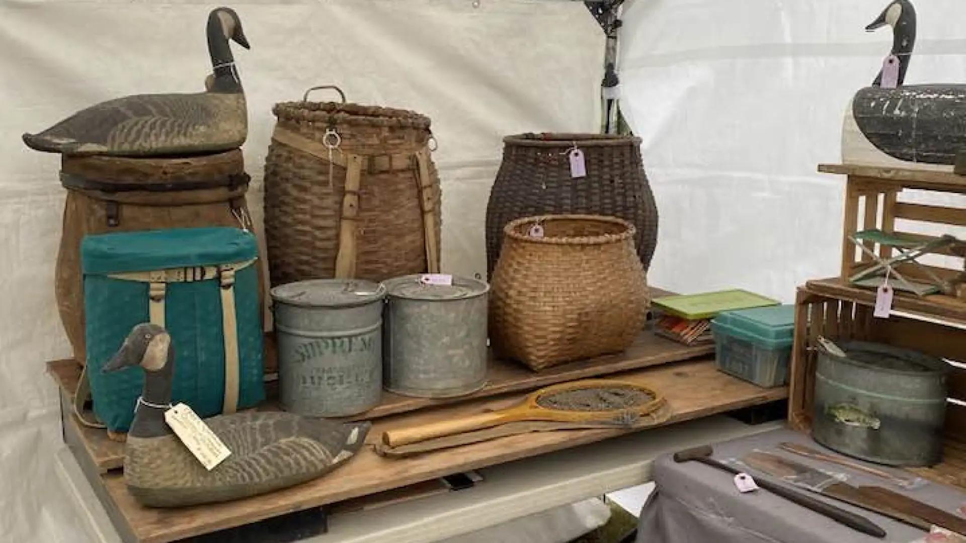 A table of old pack baskets and duck decoys