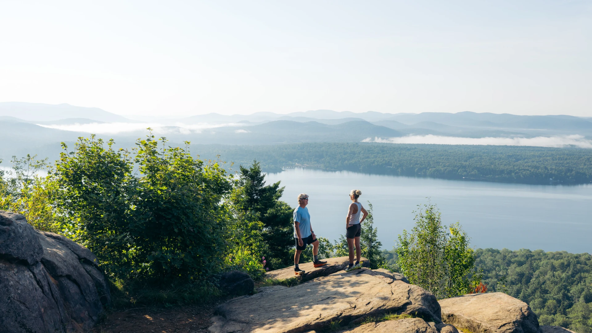 An older couple on a mountain overlooking a lake