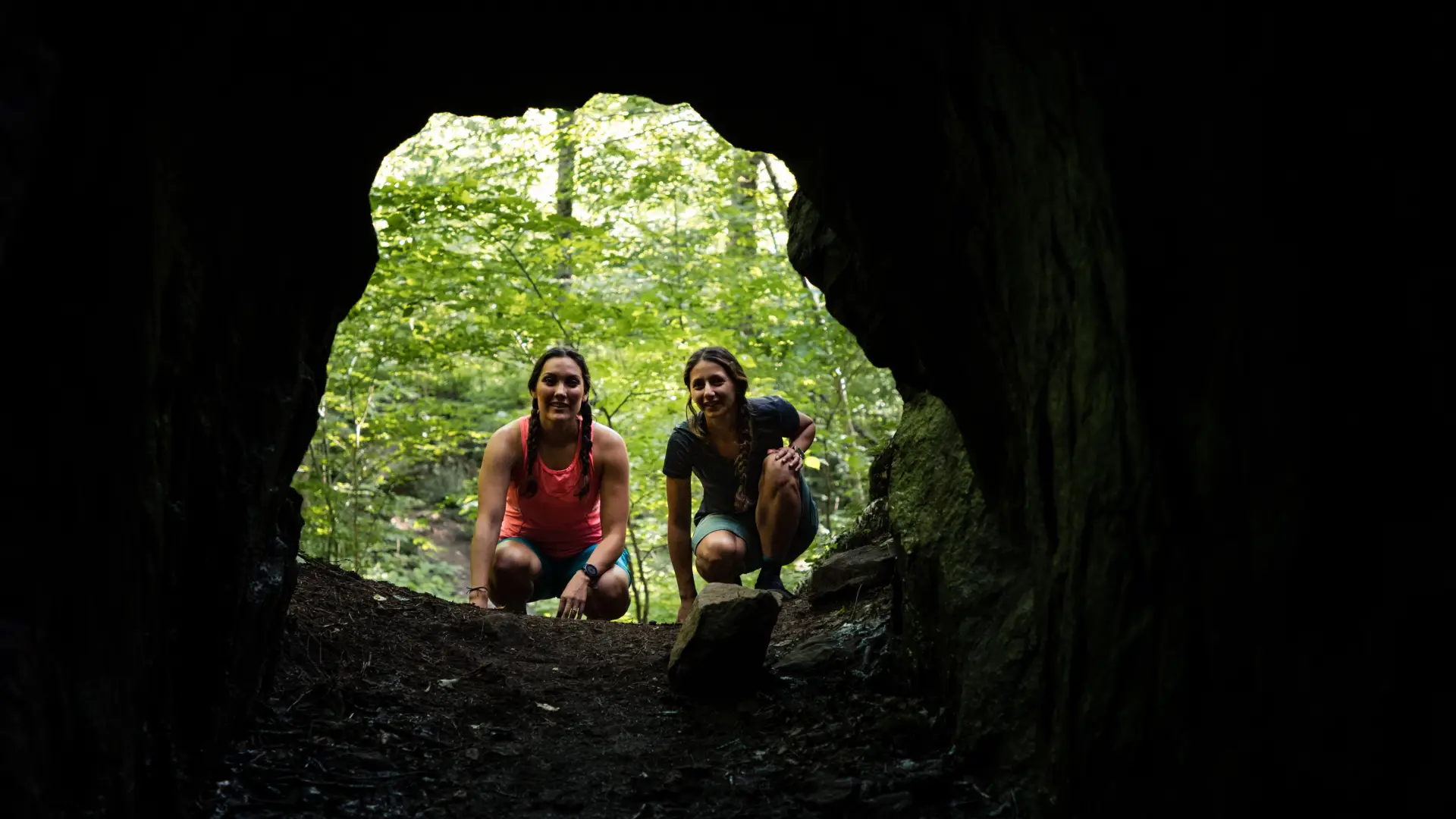 Two women looking down into Kunjamuk Cave.