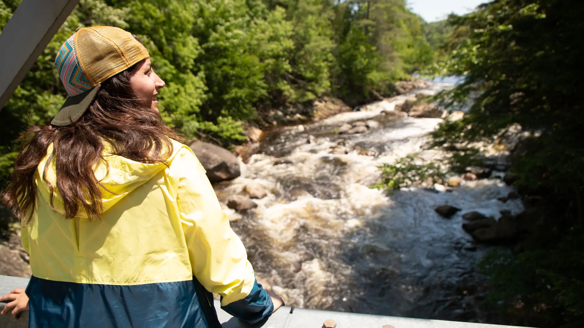 A woman looks out from a bridge over the Sacandaga River during her hike to Griffin Falls