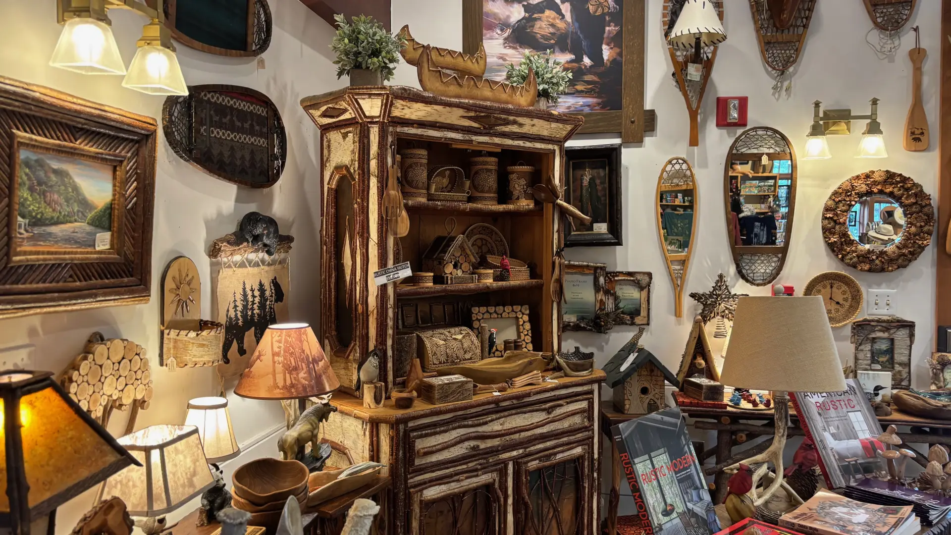 A huge range of rustic decor from bark picture frames to show shoe lamps surrounding a birch bark hutch.