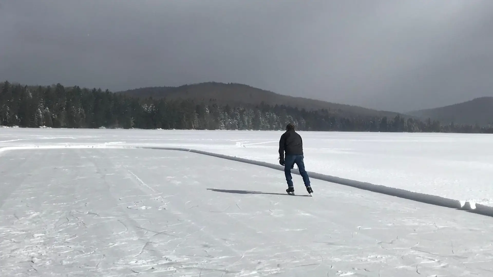 A man ice skating on the frozen lake