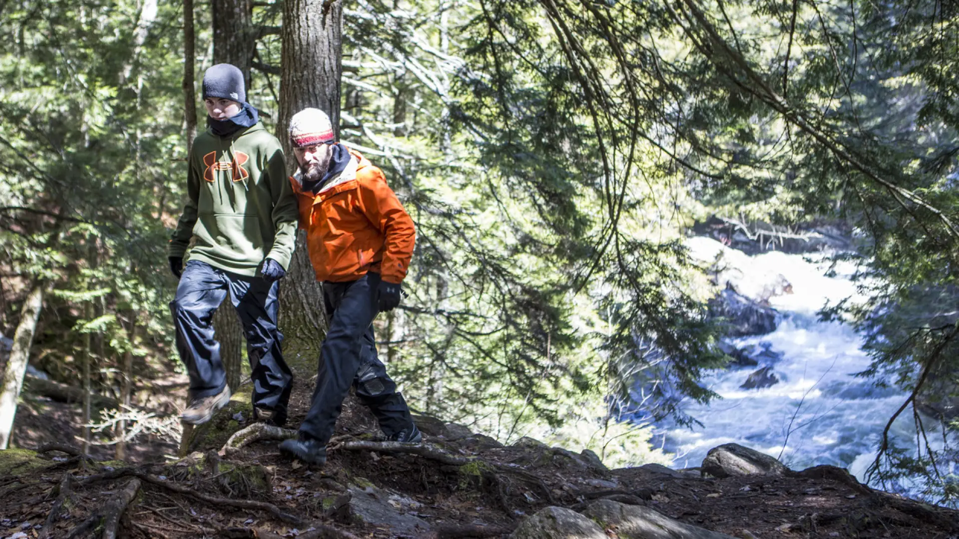 Two males hiking with Auger Falls' spring run behind them
