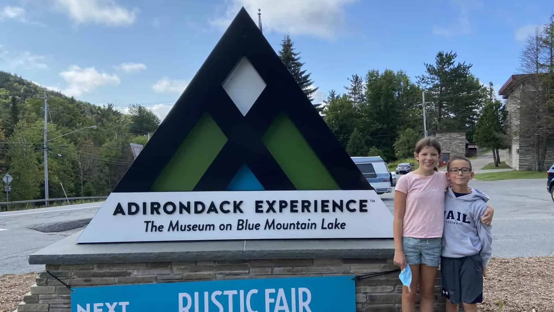 Two children standing in front of the ADX sign