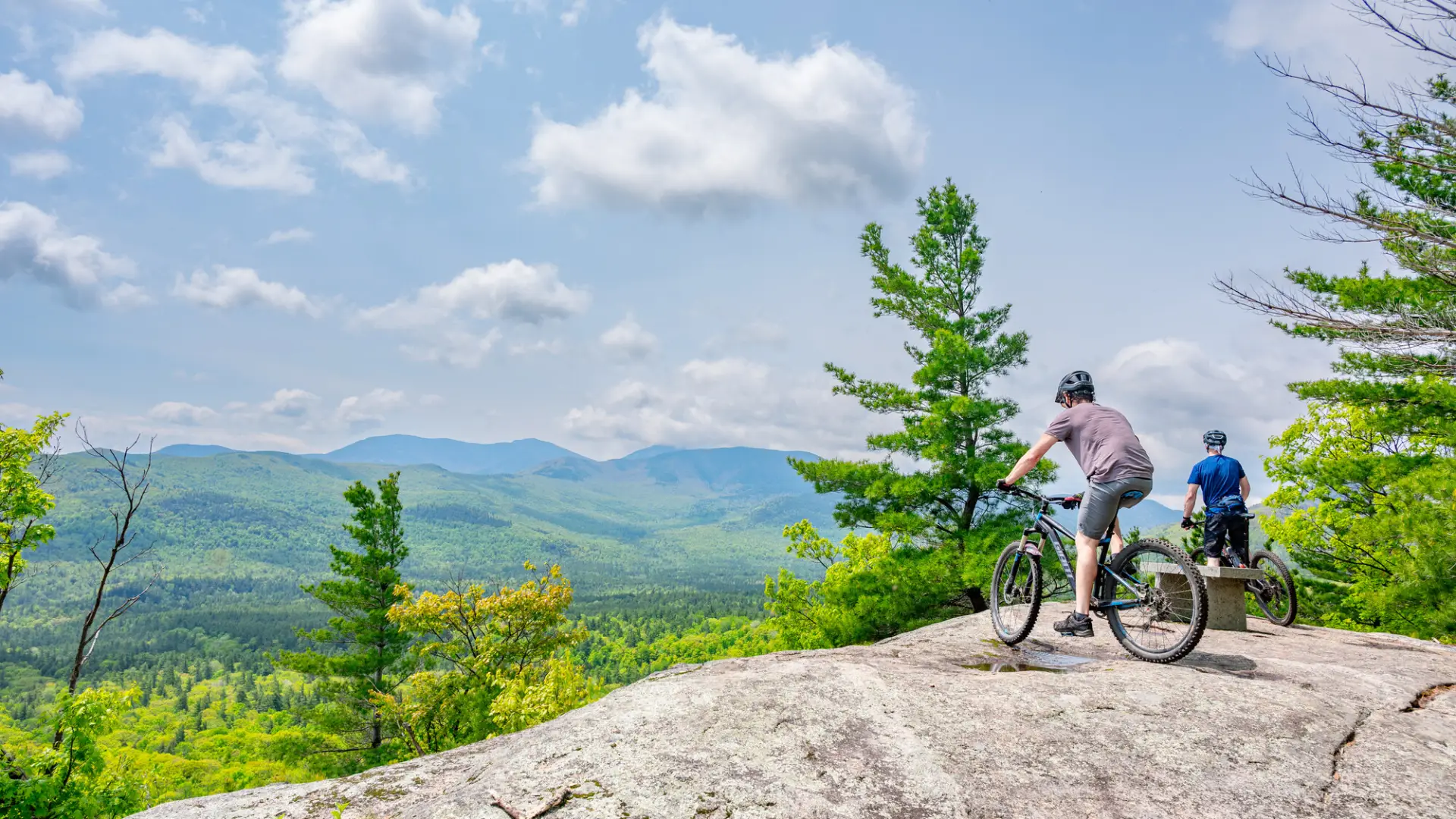 Two mountain bikers hang out at an open summit