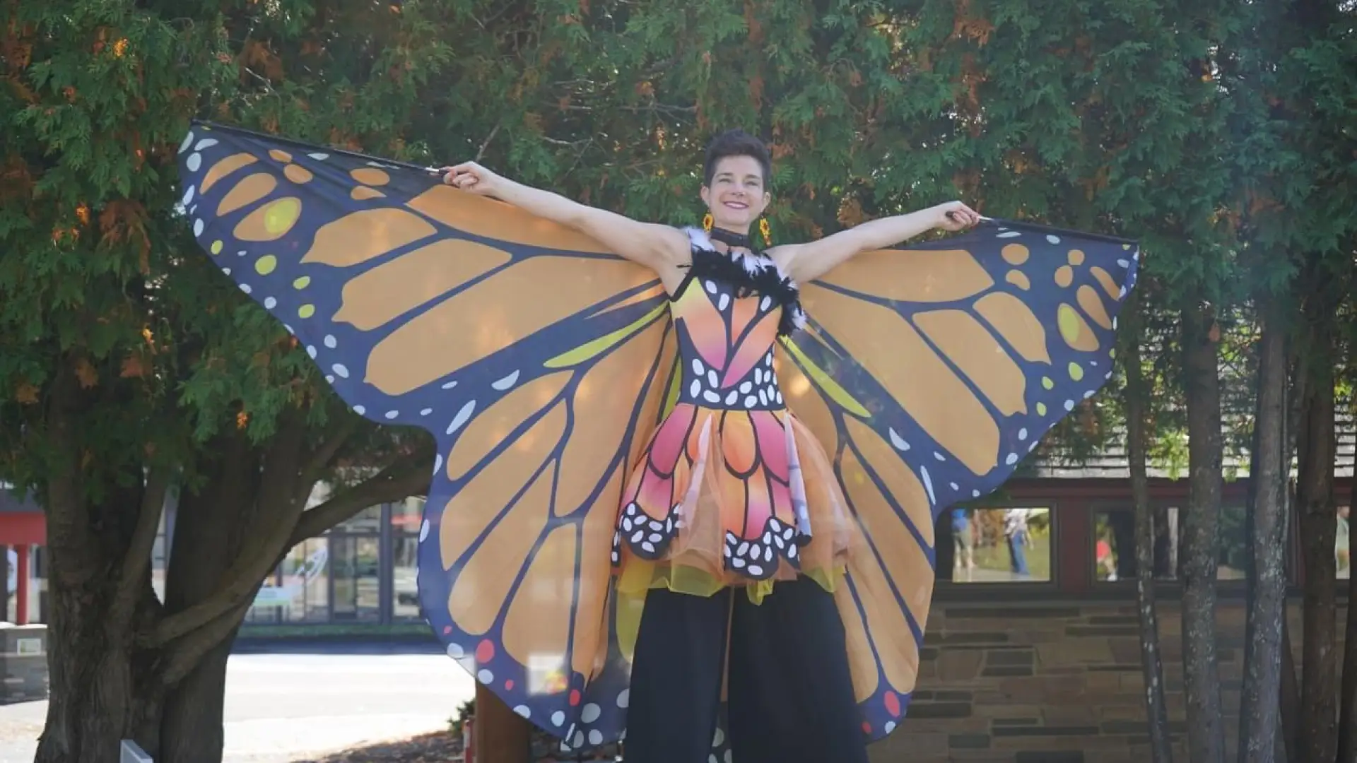 A lady dressed in a monarch costume on stilts