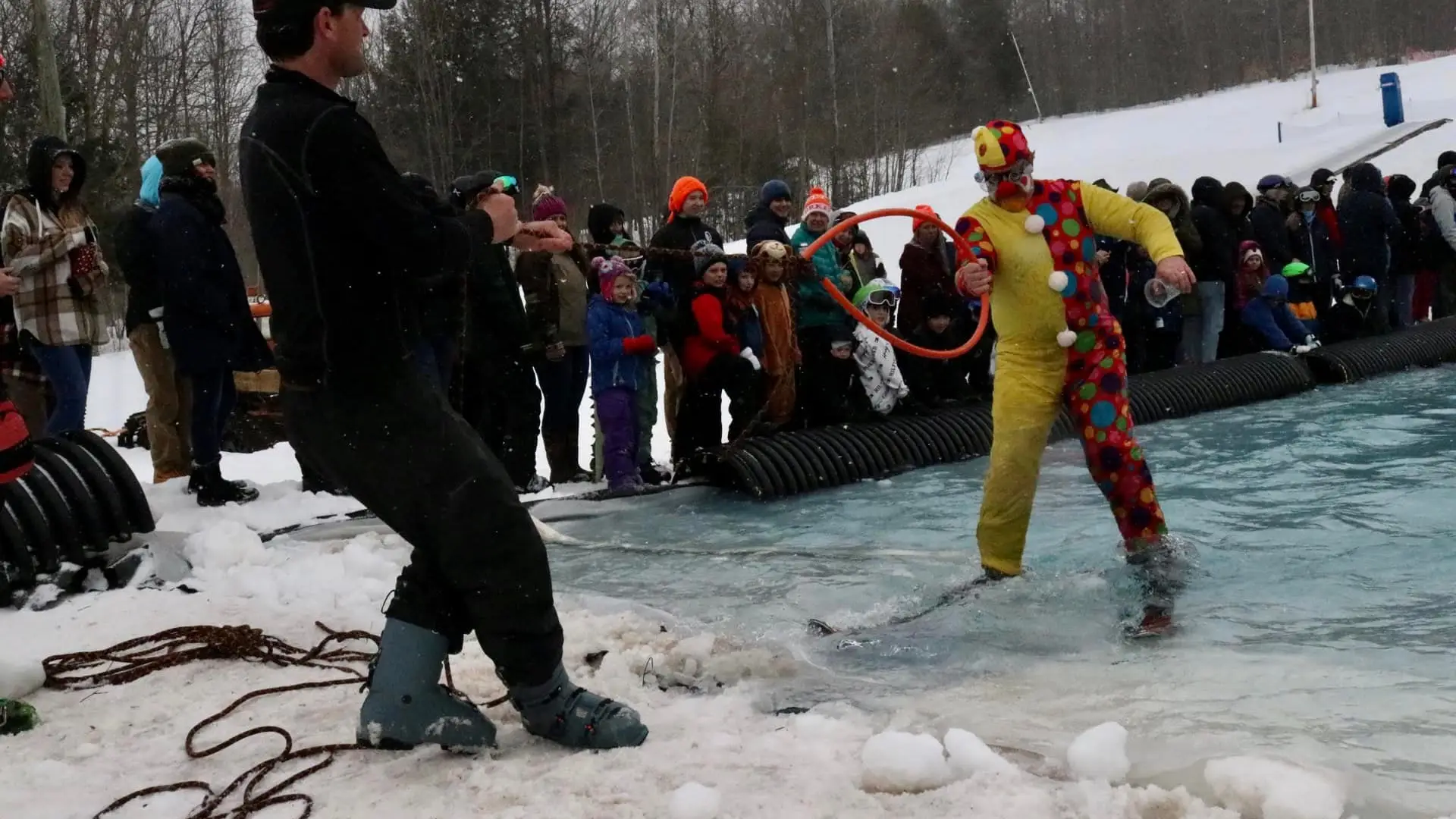 a person dressed as a clown being pulled out of the pool with a ring bouy