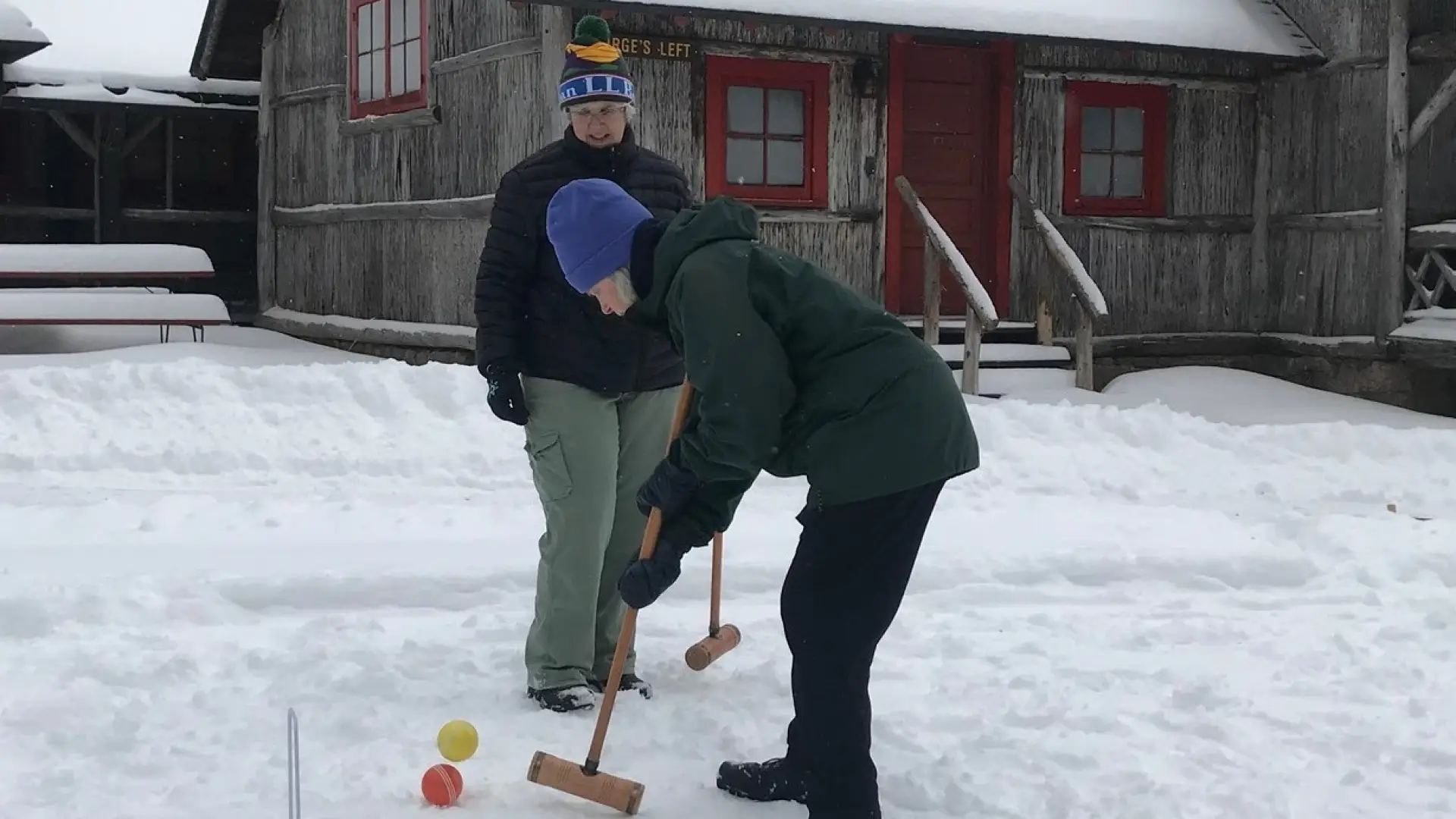 a couple of people playing snow croquet