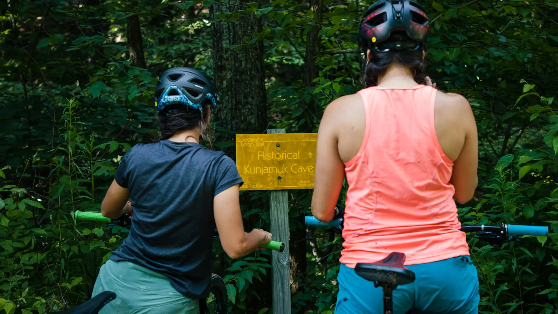 Two bikers looking at the sign for Kunjamuk Cave.