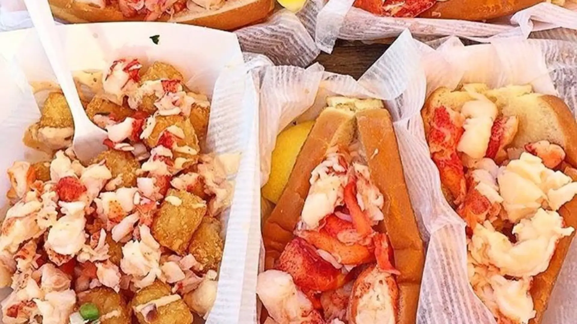 several different food items from the lobster truck like lobster and tots and a lobster roll