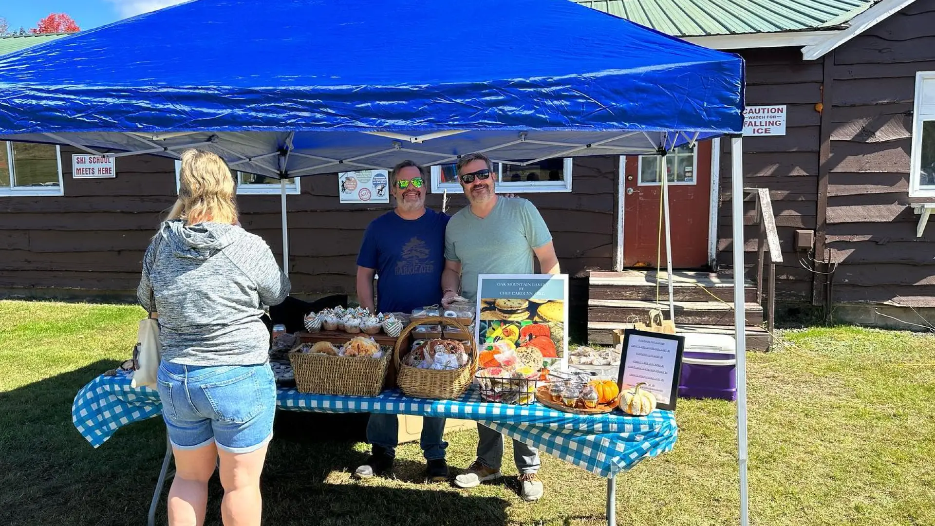 A person buying sweets at a vender tent selling baked goods