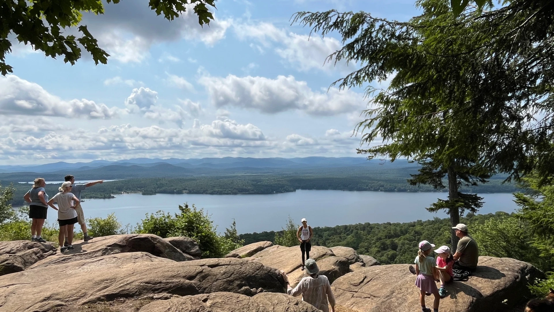 People at an overlook on a cliff with a view of the water