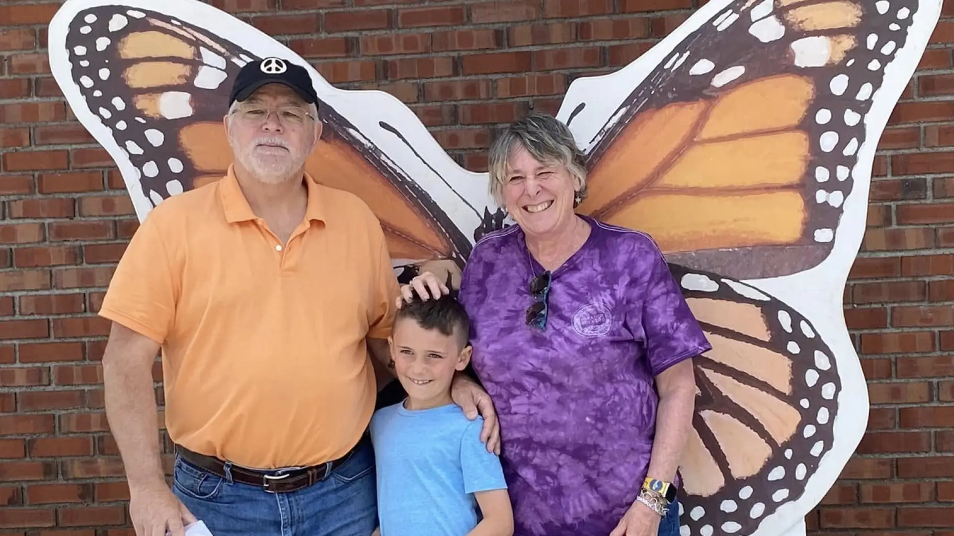 A familt posing in front of the monarch photo prop