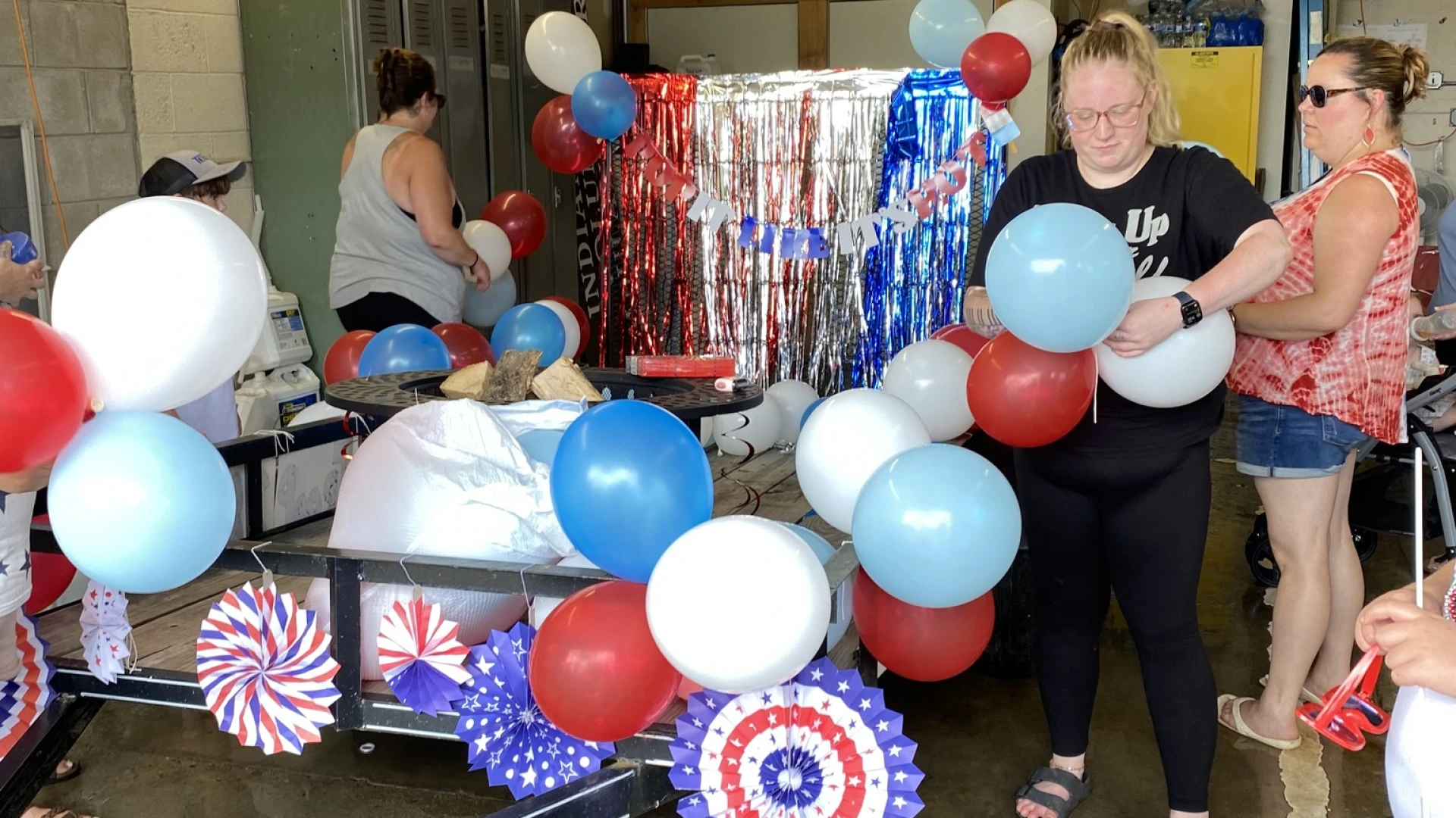 Goupr decorating a float for the parade with balloons and streamers