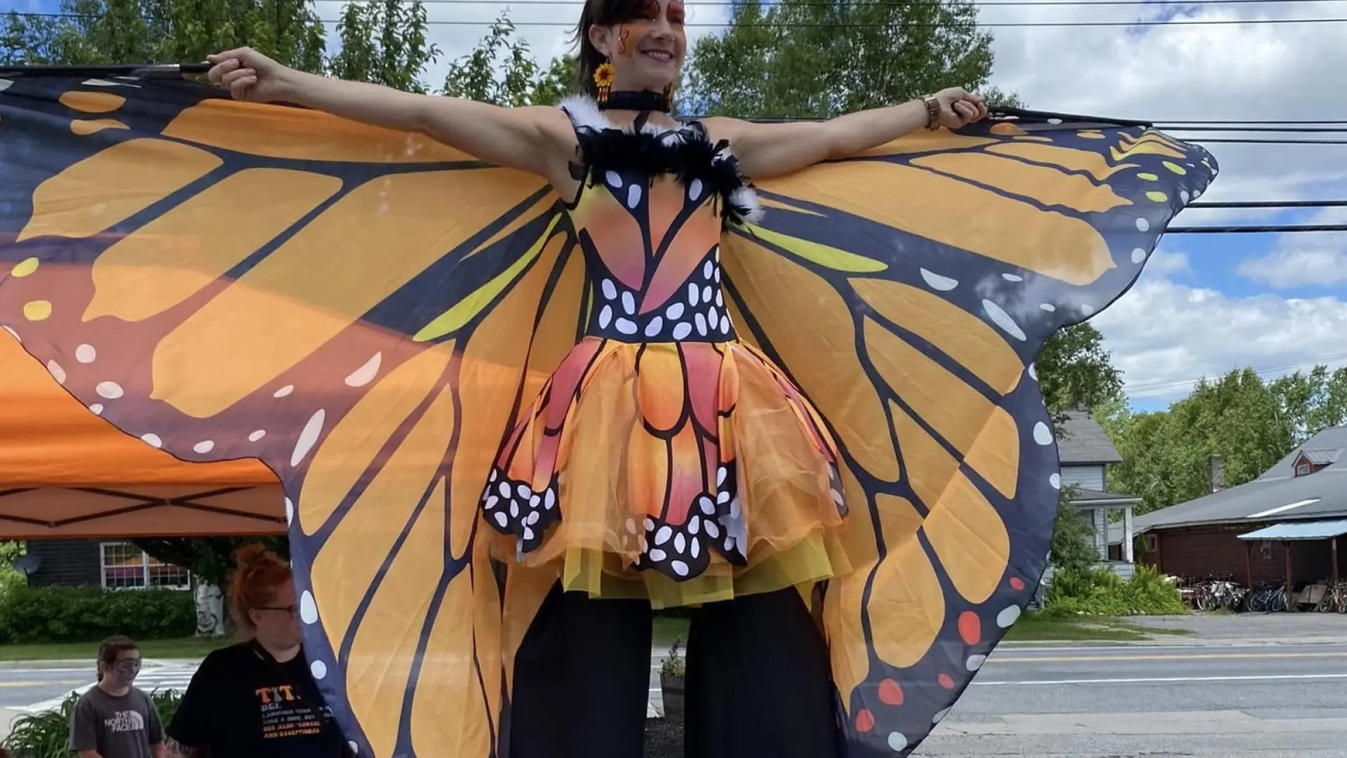 A lady dressed in a monarch costume on stilts