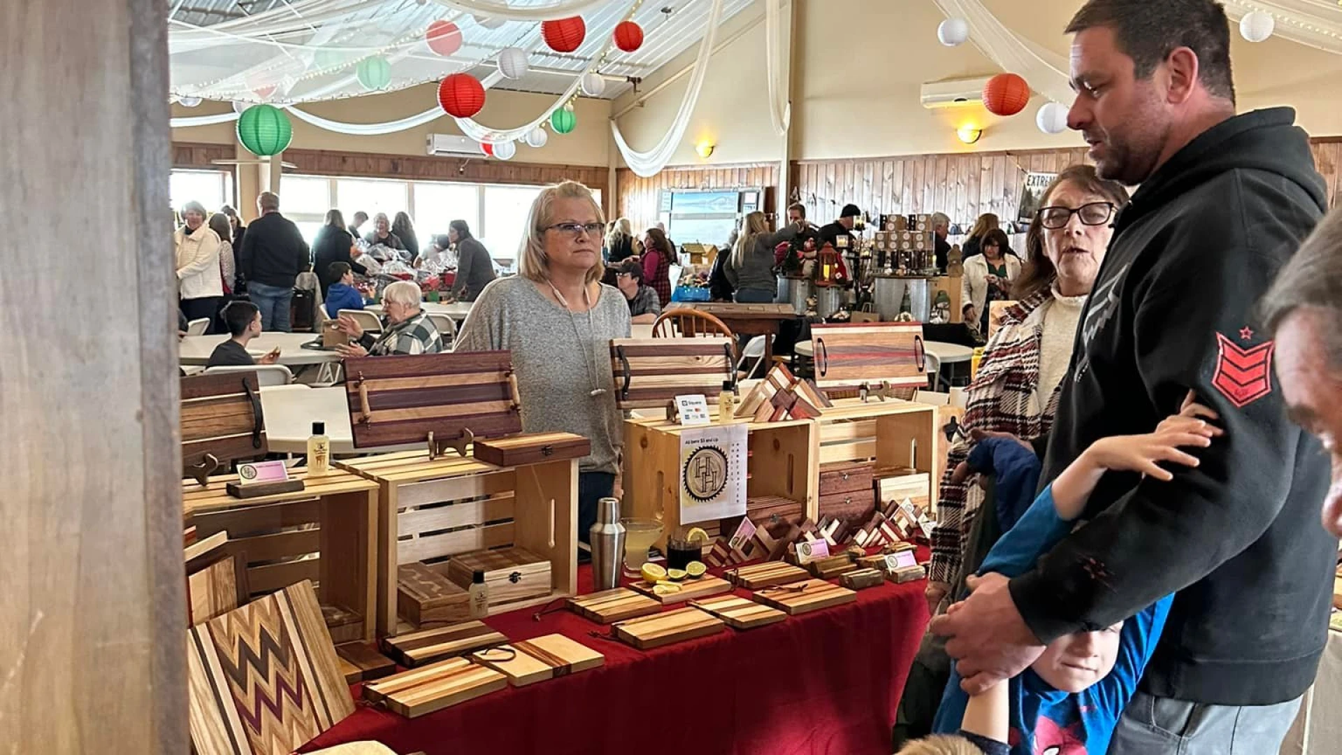 Vendor selling hand-made wooden objects like cutting boards