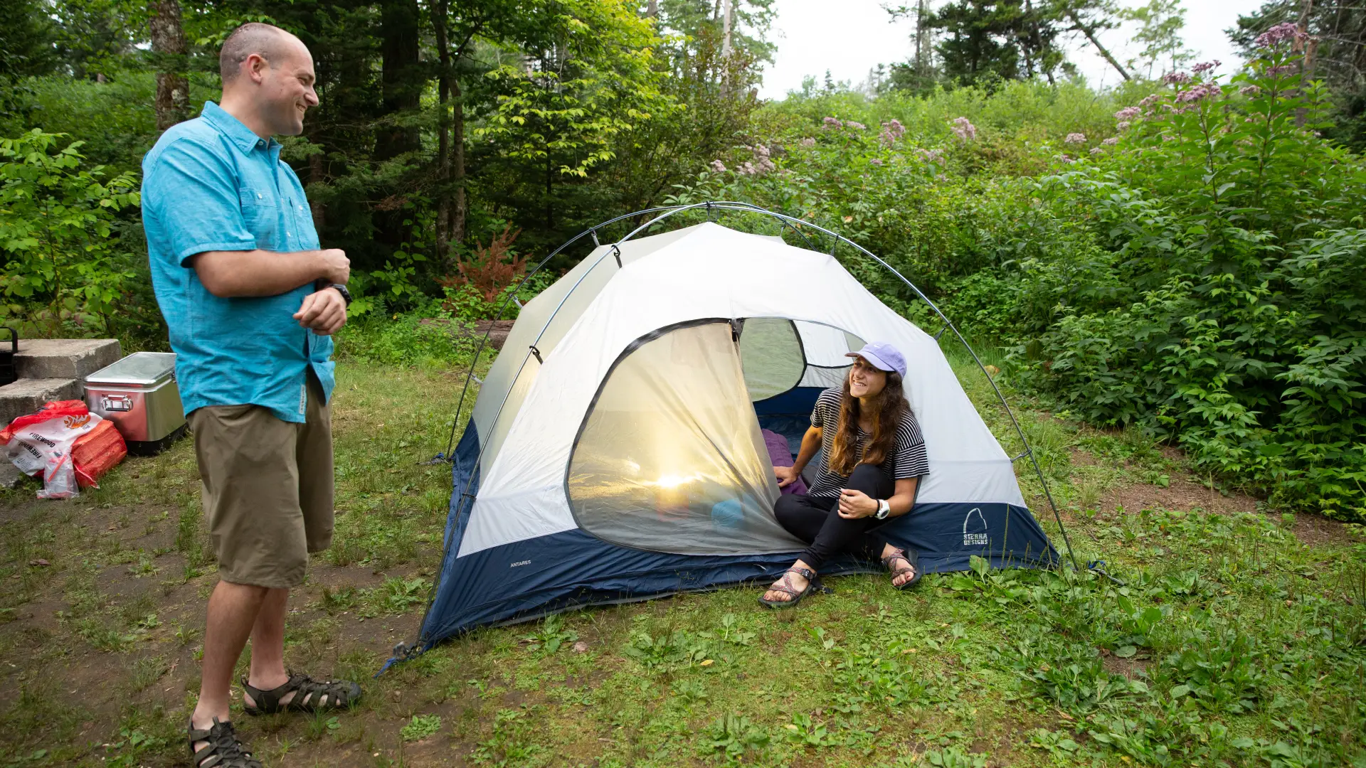 A couple converses by a tent at a Lewey Lake Campground campsite