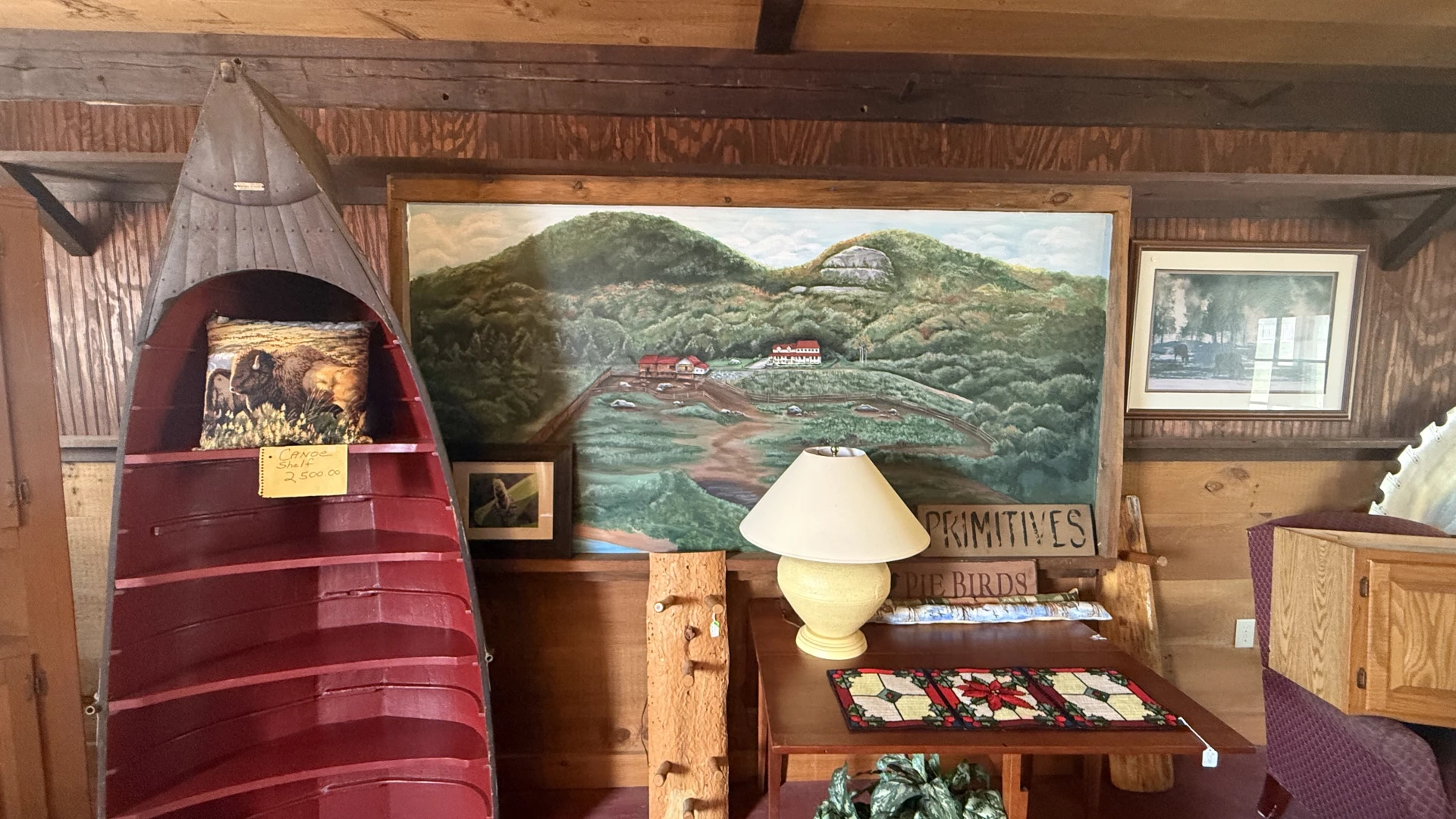 A large painting of the buffalo pasture with the buildings looking down over them.