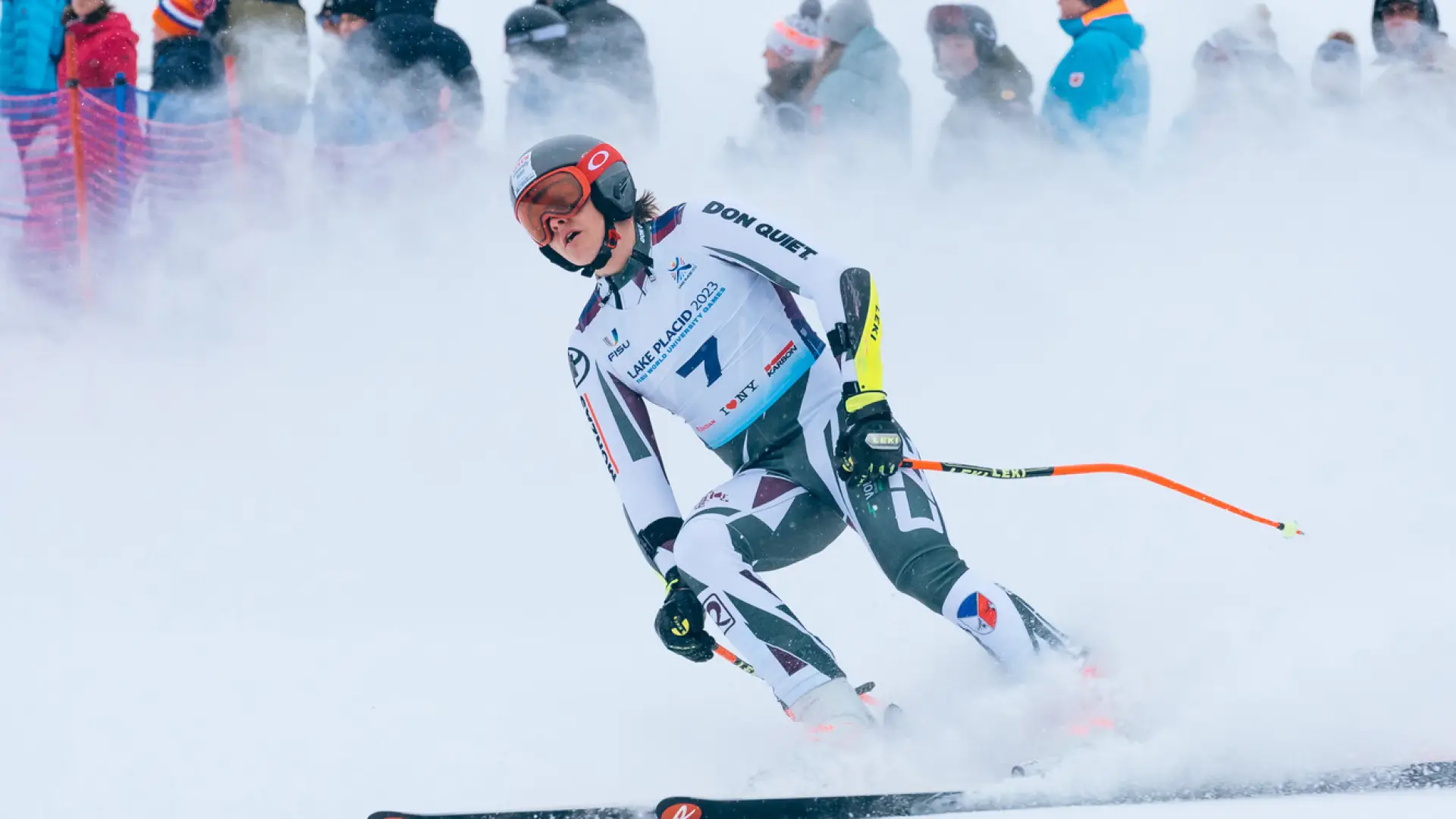 a slalom skiier in all their racing gear skiing down the hill