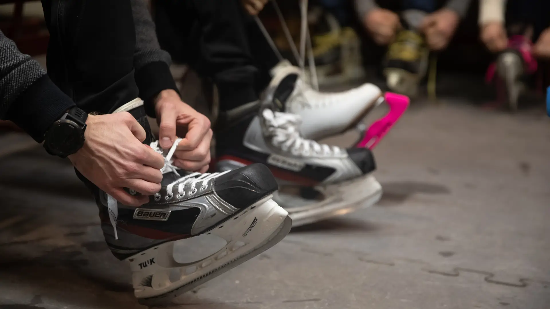 People tying their ice skates