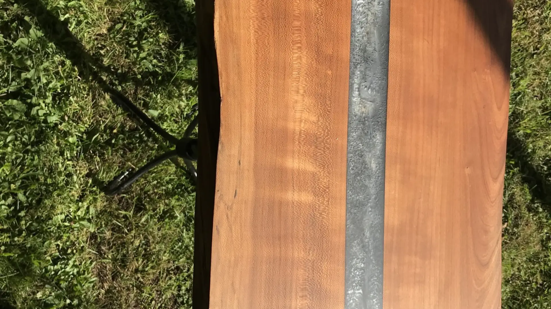 A table made from a wood slab with a center line down it made of another material