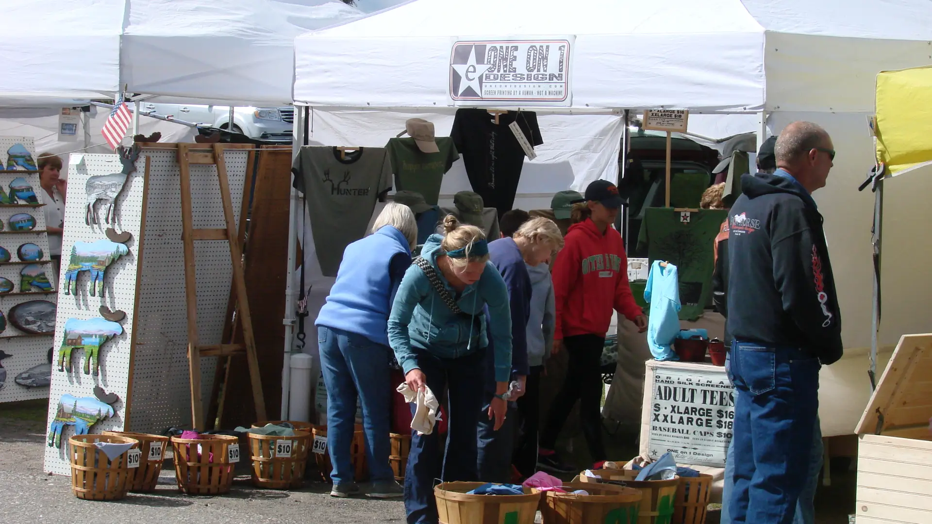 Vendor tents up on a row with people walking amongst them shopping