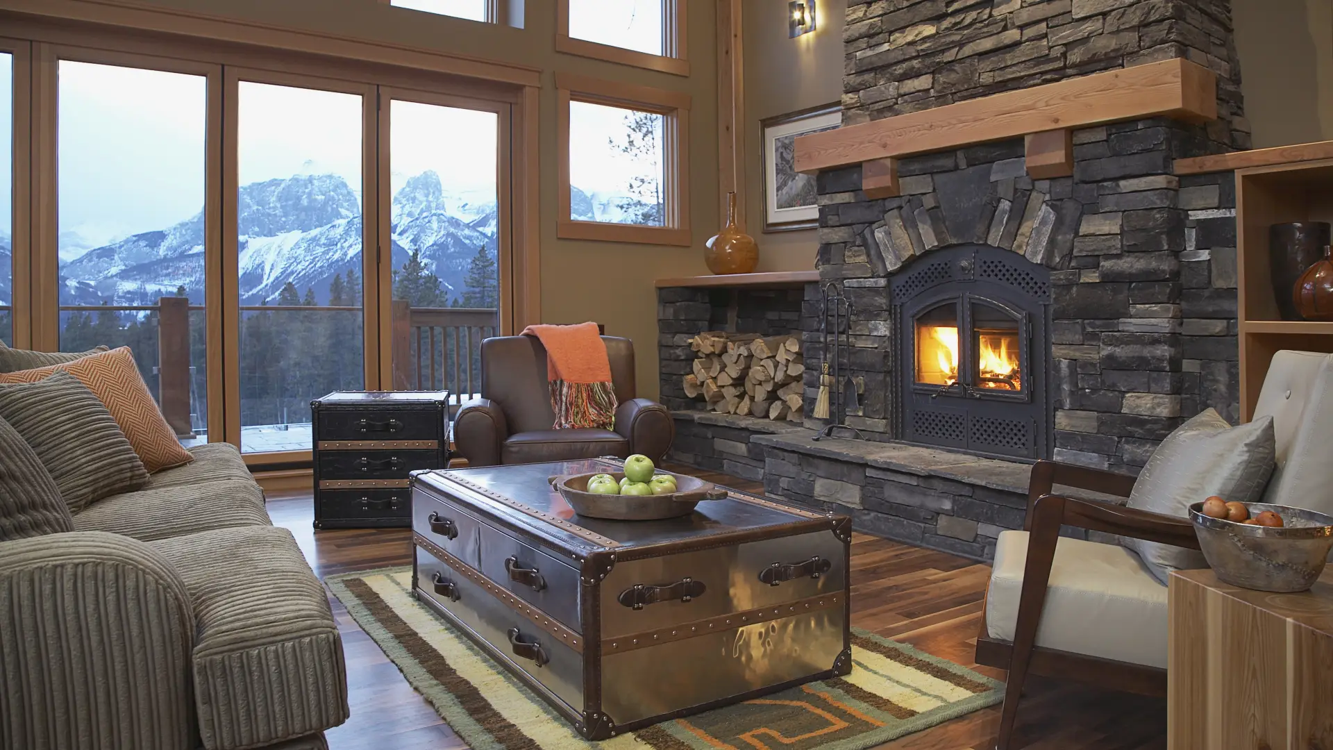 A grand living room with stone hearth and mountain views