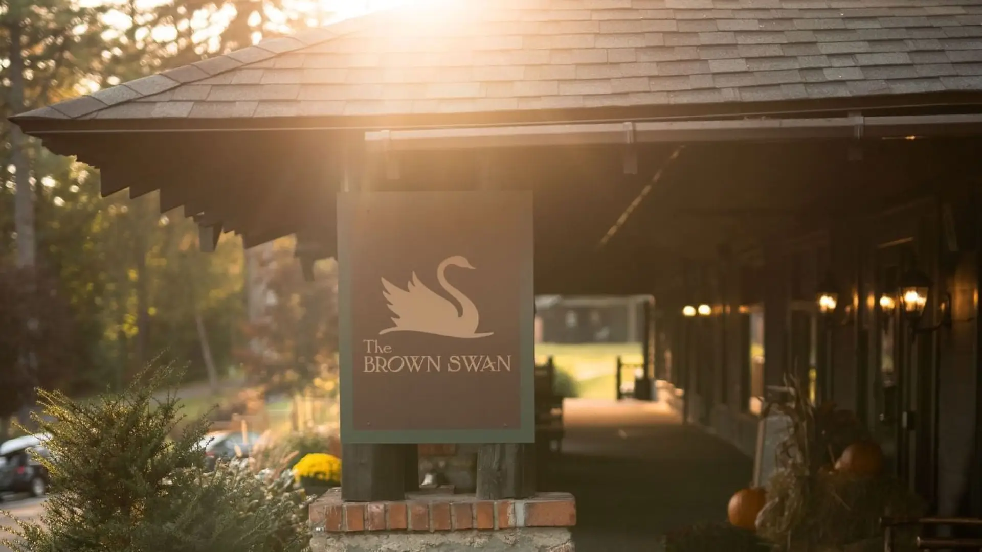 Sign for the Brown Swan on a stone pillar at golden hour.
