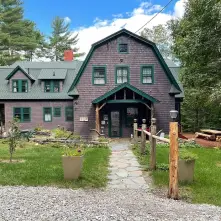 picture of the front of the Tavistock Lodge. Brown Building with Green Roof 