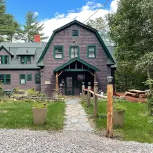 picture of the front of the Tavistock Lodge. Brown Building with Green Roof 