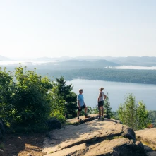 An older couple on a mountain overlooking a lake
