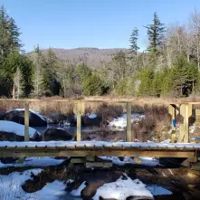 A wooden bridge lightly covered in snow