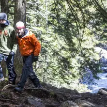 Two males hiking with Auger Falls' spring run behind them