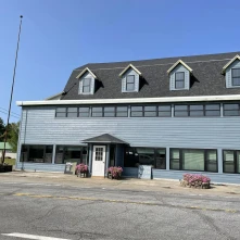 Exterior of a large building with ample parking space an a sign reading Tracy's Rustic Relics