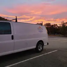 White utility van with Moulton logo at sunrise