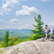 Two mountain bikers hang out at an open summit