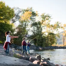 a family fishing by the lake on a sunny day