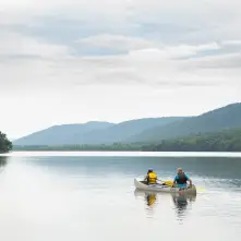 Two people in a canoe paddle across Lewey Lake.