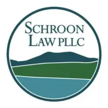 A round emblem with an abstract illustration of a blue lake, green lawn and 