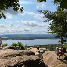 People at an overlook on a cliff with a view of the water