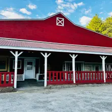 An image of the exterior of the Hay Fields antiques barn which is red with white trim.