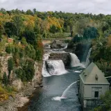 Water crashes over the falls with a building near by