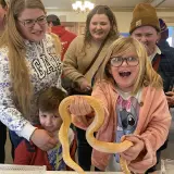 group at event holding a snake